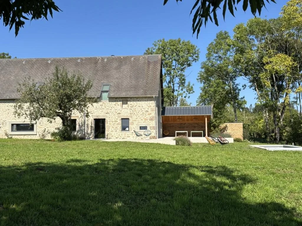 La longue façade en pierre du gîte, le pommier et la grande pelouse